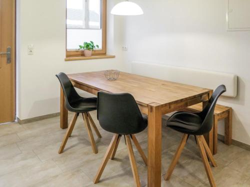 a wooden table with four black chairs around it at Apartment Luxner - KAB138 by Interhome in Kaltenbach