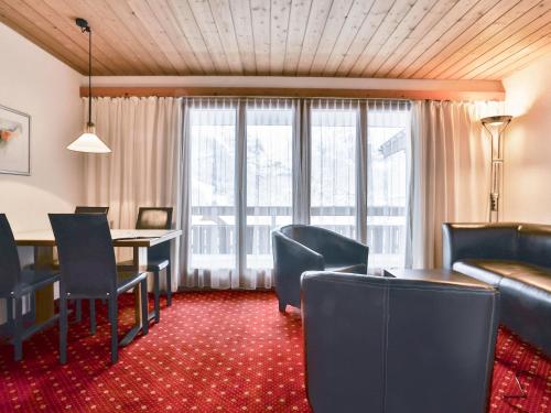 a living room with a table and chairs and a couch at Apartment Chalet Abendrot-21 by Interhome in Grindelwald