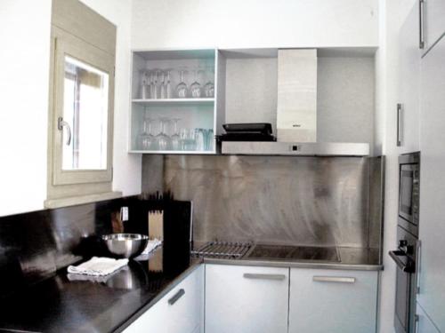 アンゼールにあるChalet Annabel by Interhomeのキッチン(白いキャビネット、黒いカウンタートップ付)