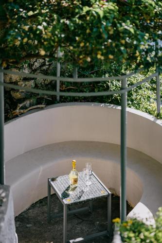 a bottle of wine sitting on a table with glasses at Villa Eris Amalfi Coast in Conca dei Marini