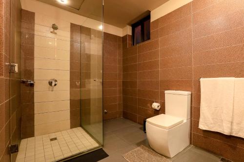 a bathroom with a toilet and a glass shower at Vienna City Hotel in Tema