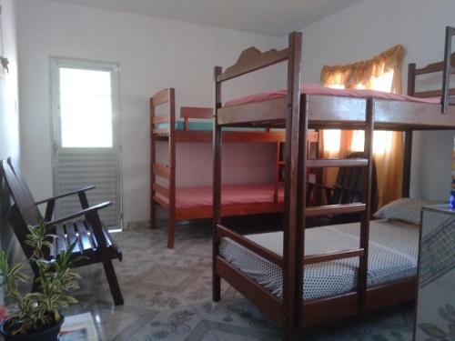 a room with three bunk beds in a room at Hostel Viajante Marajo in Soure