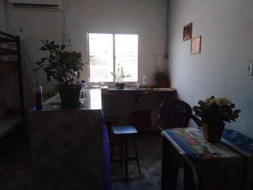 sala de estar con mesa, sillas y ventana en Hostel Viajante Marajo, en Soure