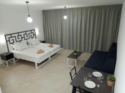 a bedroom with a bed and tables in a room at Pagona Holiday Apartments in Paphos City