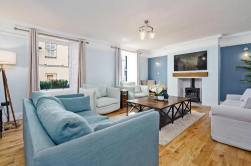 a living room with a blue couch and a table at Clovelly House Relaxed Family Coastal Home in Berwick-Upon-Tweed