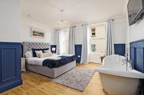 a bedroom with a bed and a tub and a sink at Clovelly House Beautiful 5 bedroom, 5 bathroom home in Berwick-Upon-Tweed