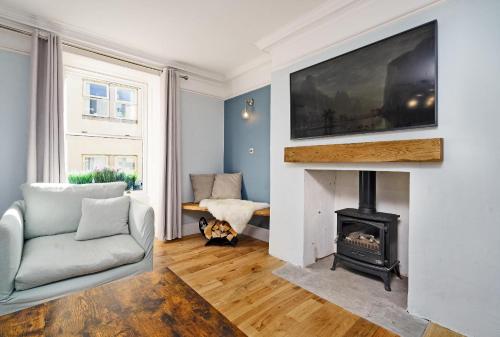 a living room with a fireplace with a tv above it at Clovelly House Relaxed Family Coastal Home in Berwick-Upon-Tweed