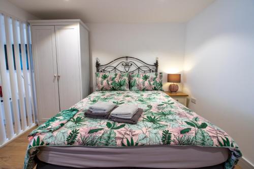 a bedroom with a large bed with a floral bedspread at Stylish Studio in the Heart of the English Riviera in Torquay