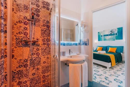 a bathroom with a shower and a sink and a bed at Villa Eris Amalfi Coast in Conca dei Marini