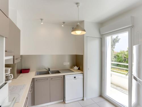 uma cozinha com armários brancos e uma janela em Apartment Comete by Interhome em Anglet