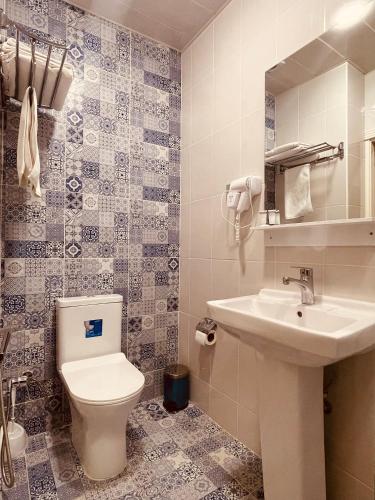 a bathroom with a toilet and a sink at Moss Art Boutique Hotel in Baku