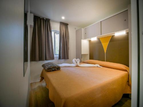 a bedroom with a bed with two towels on it at Camping Village Free Time in Marina di Bibbona