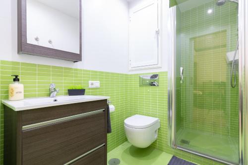 a green tiled bathroom with a toilet and a shower at SW Mendoza 20 in Málaga