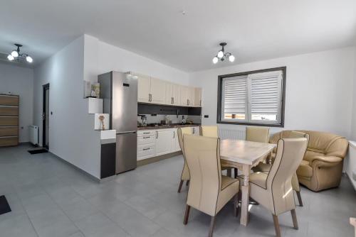 a kitchen and dining room with a table and chairs at Pensiunea RAVHOUSE in Vadu Izei