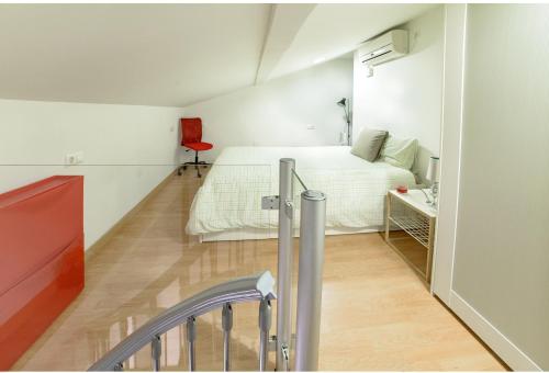 マラガにあるSW Charming Duplexの小さなベッドルーム(ベッド1台、赤い椅子付)