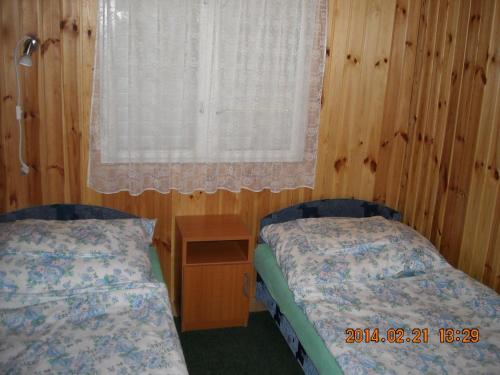 1 dormitorio con 2 camas individuales y ventana en Demeter Apartman, en Hajdúszoboszló