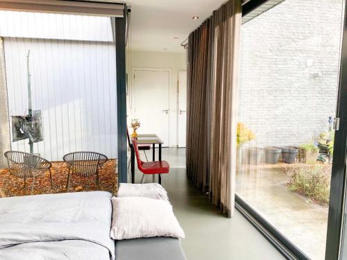 een slaapkamer met een bed en een groot raam bij B&B Winterresidentie in Tilburg