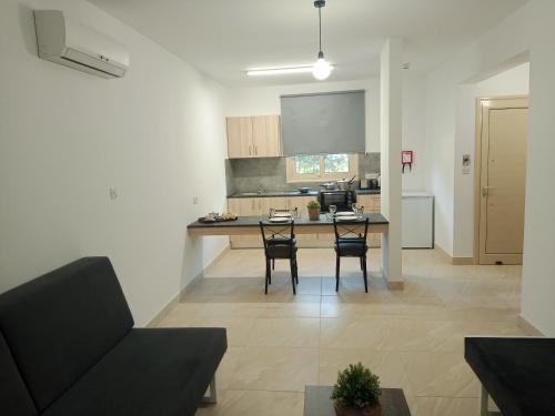 a kitchen and living room with a table and chairs at Pagona Holiday Apartments in Paphos City
