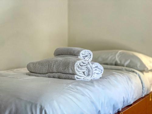 un mucchio di asciugamani seduti sopra un letto di Appartamento Smith Malvasia - Solo Affitti Brevi a Bardonecchia