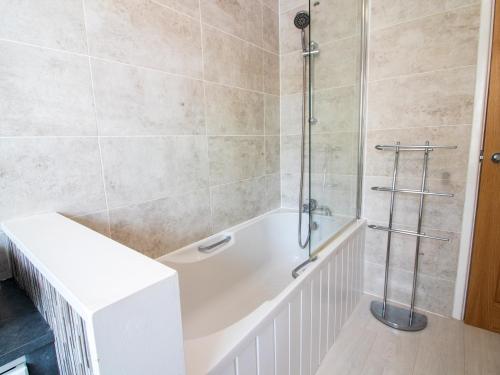 a bathroom with a white tub and a shower at Stylish Home in the heart of the English Riviera in Torquay