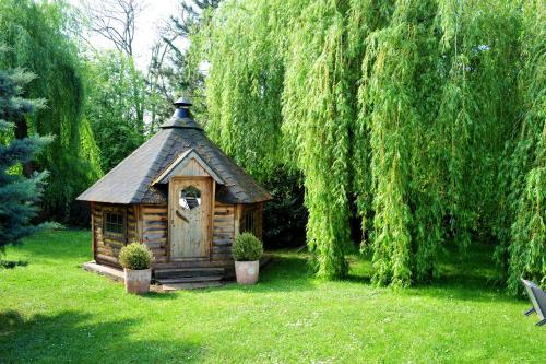 eine kleine Holzhütte in der Mitte eines Gartens in der Unterkunft Les Jardins D'Adalric in Obernai