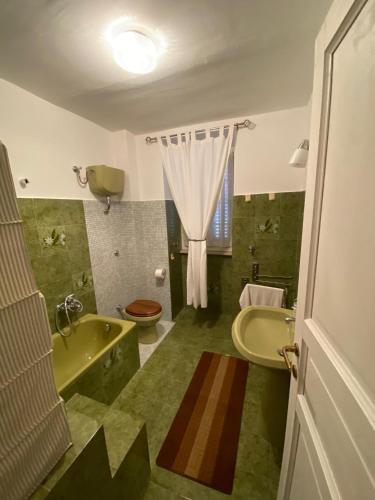 a bathroom with a tub and a toilet and a sink at Holiday Home Falchetta in Palena