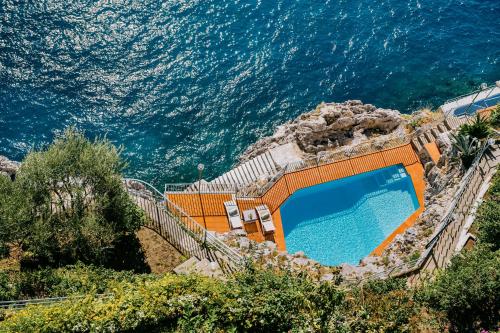 a swimming pool with the ocean in the background at Villa Eris Amalfi Coast in Conca dei Marini