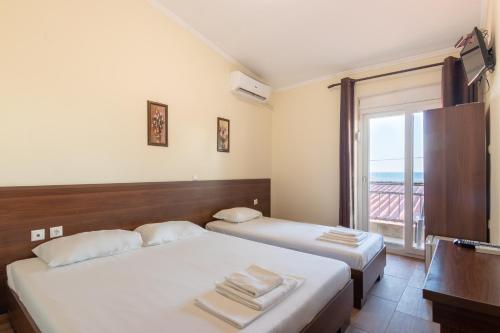 two beds in a room with a balcony at Myrodato Rooms in Xanthi