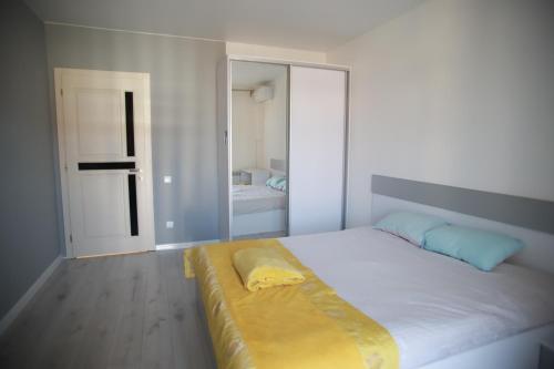 a bedroom with a large white bed with a yellow bench at Апартаменти Віланж in Polyana
