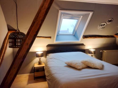a bedroom with a white bed with a window at Grytmanshoeve, Vakantiehuis met glamping in Niawier