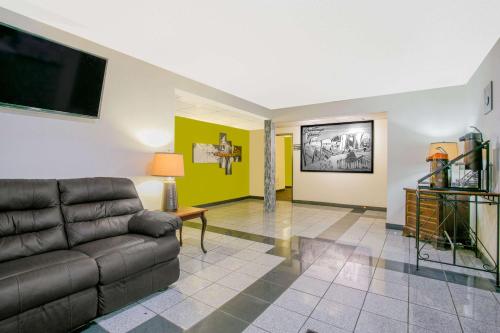 a living room with a couch and a tv at Super 8 by Wyndham South Boston VA in South Boston