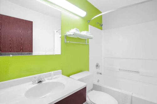 uma casa de banho com um lavatório branco e uma parede verde em Super 8 by Wyndham South Boston VA em South Boston