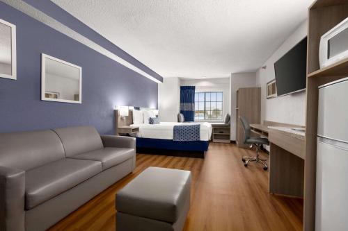 a hotel room with a bed and a couch at Microtel Inn & Suites Lincoln in Lincoln