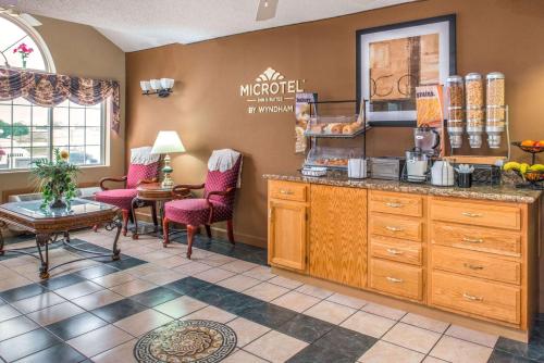 une cuisine avec un comptoir, des chaises et une table dans l'établissement Microtel Inn & Suites Lincoln, à Lincoln