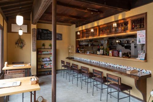 bar z rzędem stołków w restauracji w obiekcie Hostel&Cafe Farolito w mieście Ukiha