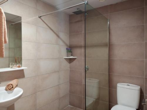 a bathroom with a shower with a toilet and a sink at Pagona Holiday Apartments in Paphos City