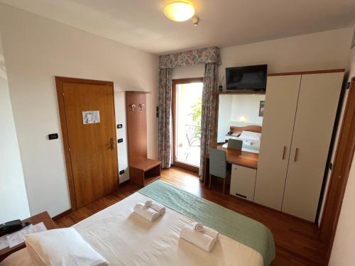 a bedroom with a bed and a desk and a window at Hotel Meridiana in Sirmione
