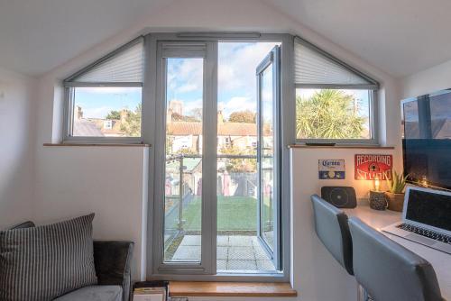 an office with a window and a desk with a laptop at Papillon, Southwold - A Modern Flat with Balcony in Southwold