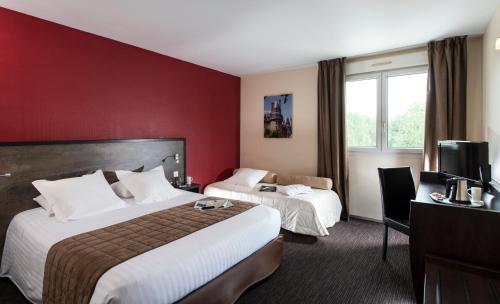 Habitación de hotel con 2 camas y pared roja en Kyriad Tours - Joué-Lès-Tours en Joue-les-Tours