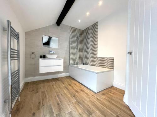 ein Badezimmer mit einer weißen Badewanne und einem Waschbecken in der Unterkunft Yr Hen Bopty (The Old Bakery) in Pontypridd