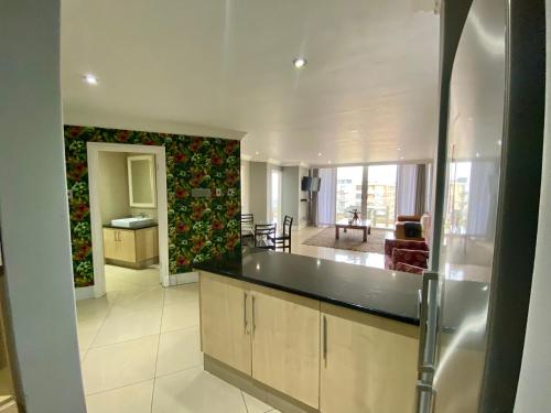 a large kitchen and living room with a counter top at Apartment The Sails in Durban