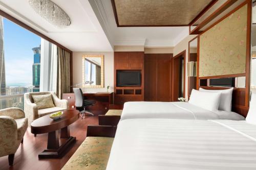a hotel room with two beds and a desk at Futian Shangri-La, Shenzhen,Near to Shenzhen Convention&Exhibition Centre, Futian Railway Station in Shenzhen