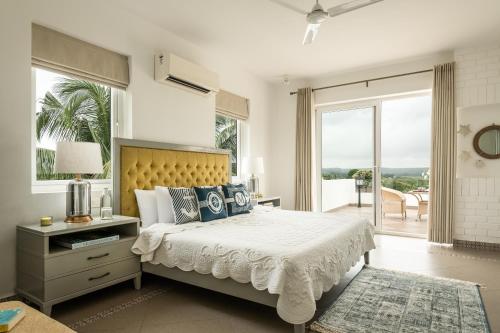 a bedroom with a large bed and a balcony at Santa Tera Homely 1&2bhk Apartments With Common Pool & Kitchen & Security & Wifi, Near to Candolim in Verem