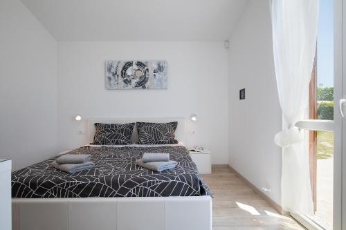 a white bedroom with a bed with pillows on it at Villa Irena in Medulin