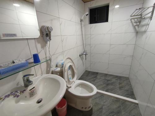 y baño con aseo y lavamanos. en 莒光英雄館民宿 B&b, en Juguang