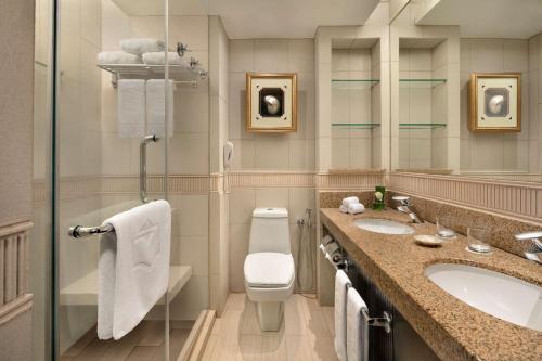 uma casa de banho com um WC, um lavatório e um espelho. em Shangri-La Golden Sands, Penang em Batu Ferringhi