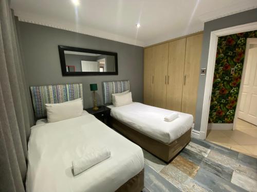 Habitación de hotel con 2 camas y espejo en Apartment The Sails, en Durban