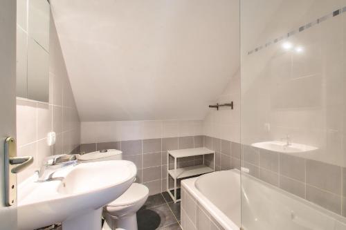 ein Badezimmer mit Waschbecken, Toilette und Badewanne in der Unterkunft NOCNOC - Gîte du Vieux Pressoir, piscine chauffée et couverte in Campbon