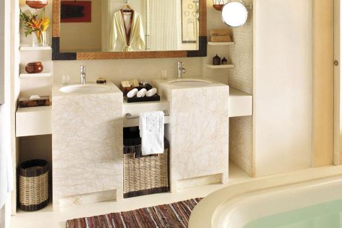a bathroom with two sinks and a mirror and a tub at Shangri-La Boracay in Boracay