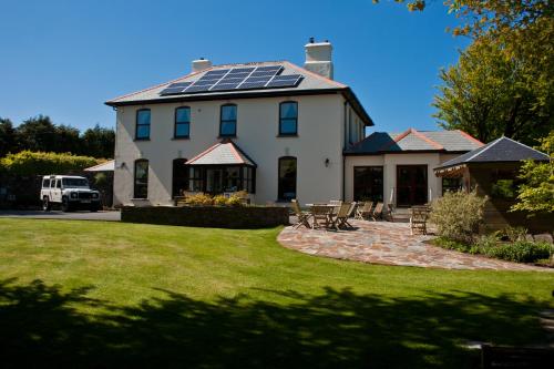 una casa con paneles solares en el techo en Pendragon Country House, en Camelford